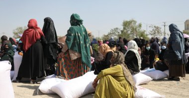 Afghan women wait to receive sacks of rice as part of humanitarian aid sent to Afghanistan at a distribution center in Afghanistan's Kabul, April 7, 2022. (Reuters File Photo)