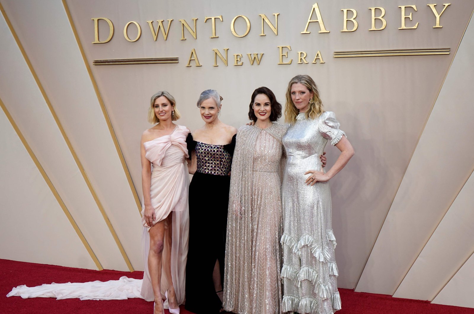 British actor Laura Carmichael (L), U.S. actor Elizabeth McGovern (2nd L), British actor Michelle Dockery (2nd R) and costume designer Anna Robbins (R) pose on the red carpet upon arrival for the world premiere of the film &quot;Downton Abbey: A New Era&quot; in London, U.K., April 25, 2022. (AFP)