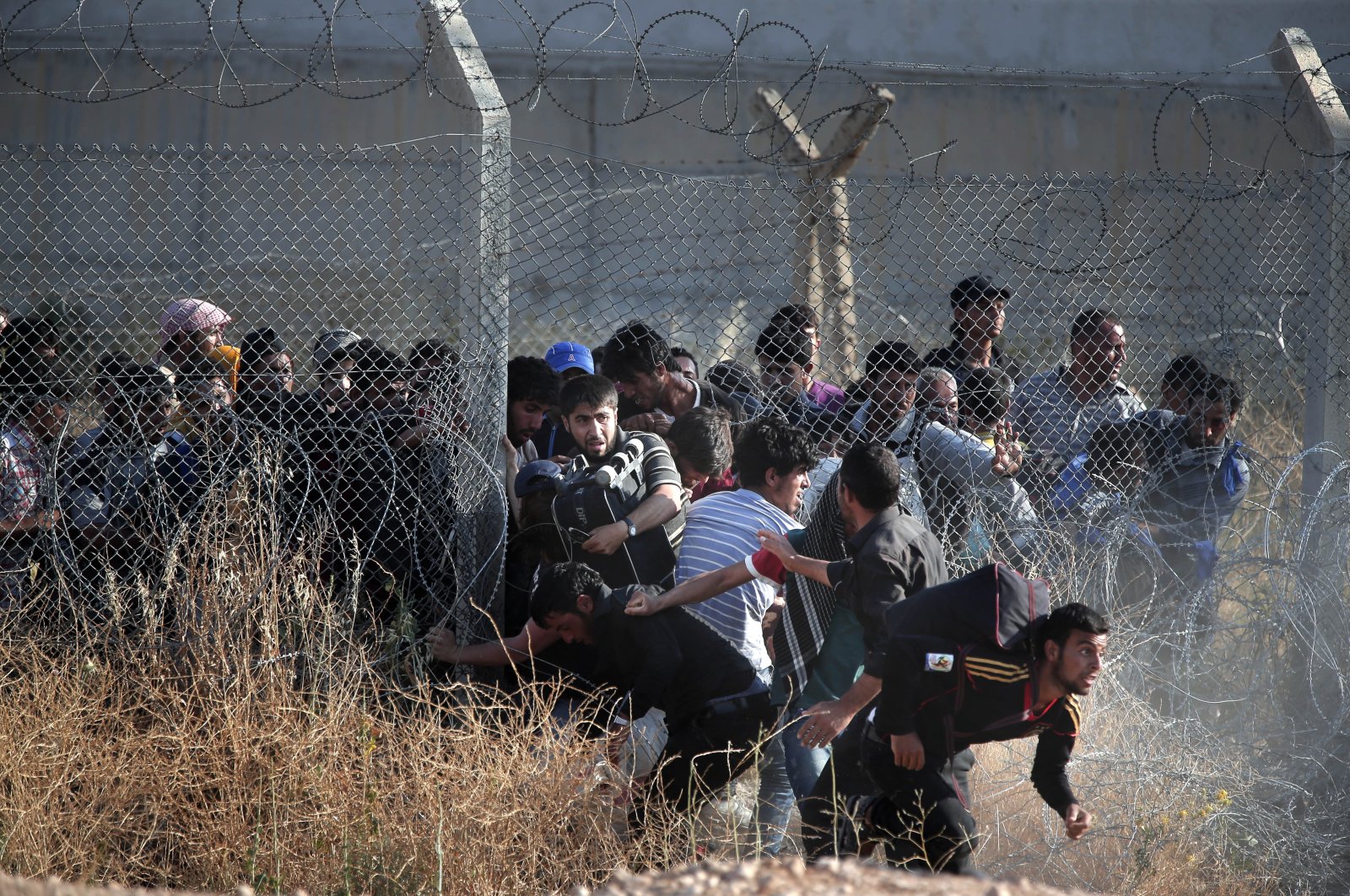 Syrian refugees cross into Turkey after breaking the border fence on June 14, 2015. (AP Photo)