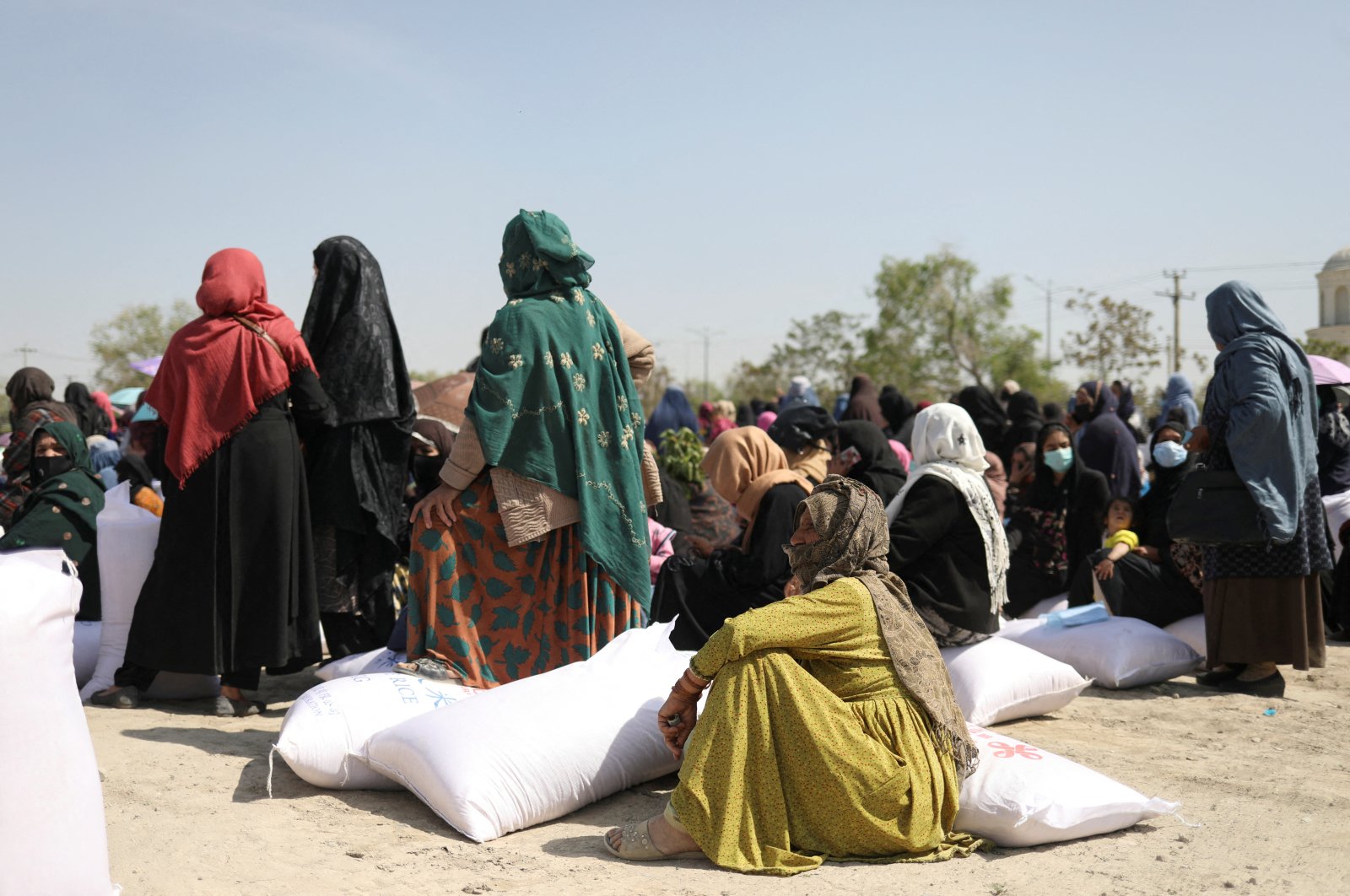 Afghan women wait to receive sacks of rice as part of humanitarian aid sent to Afghanistan at a distribution center in Afghanistan&#039;s Kabul, April 7, 2022. (Reuters File Photo)