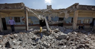 Syrians check the damage of a destroyed school after it was hit by an airstrike killing six Syrians in the town of Tal Rifaat on the outskirts of Aleppo city, Syria, Aug. 8, 2012. (AP File Photo)