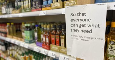 A sign asking shoppers to limit buying the amount of cooking oil is displayed on a shelf in a supermarket in Ashford, UK, April 23, 2022. (AP Photo)