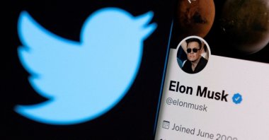Elon Musk's Twitter account is seen on a smartphone in front of the Twitter logo, April 15, 2022. (Reuters Photo)