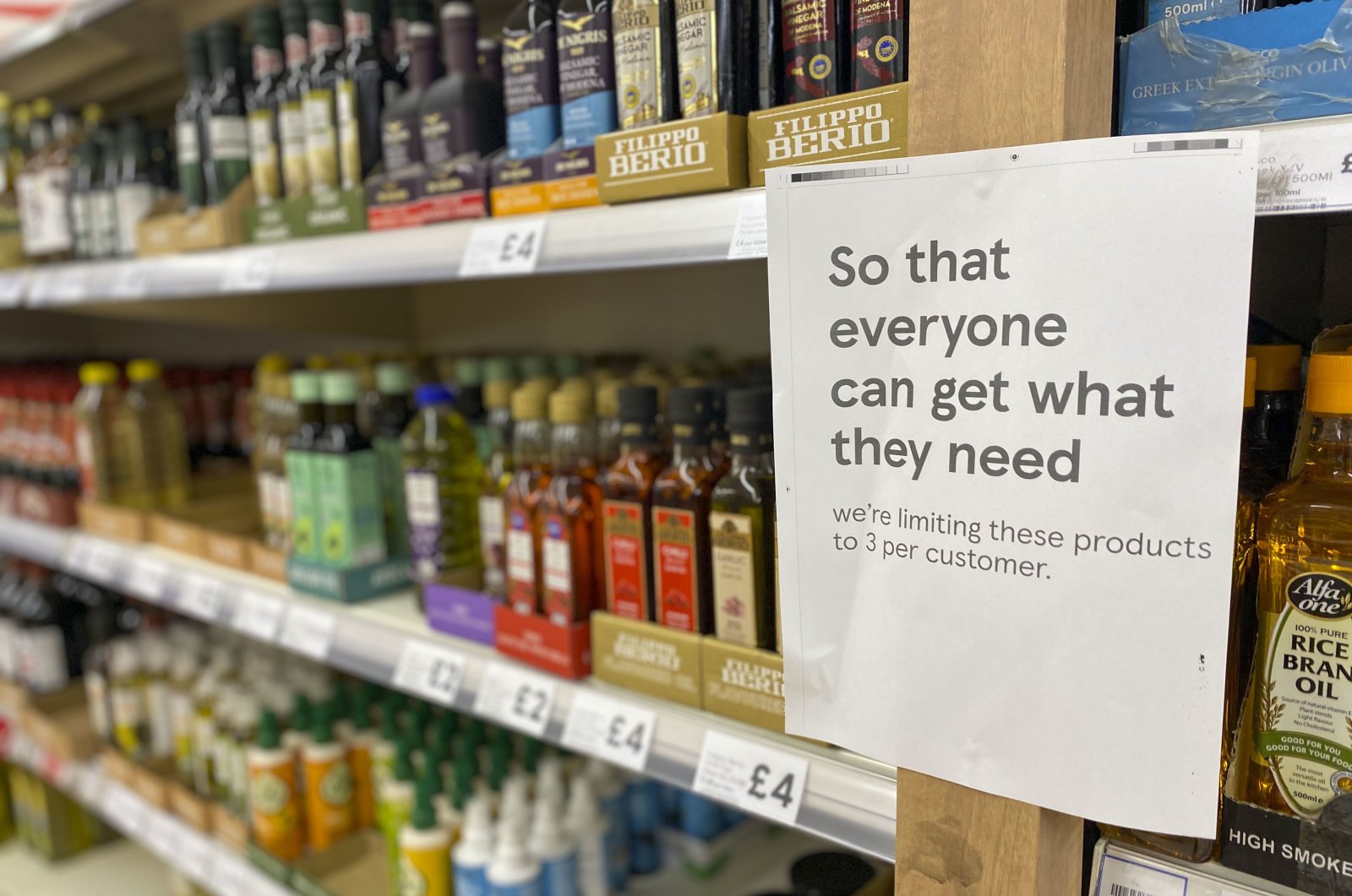 A sign asking shoppers to limit buying the amount of cooking oil is displayed on a shelf in a supermarket in Ashford, UK, April 23, 2022. (AP Photo)