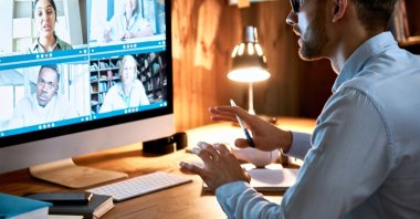 An executive leads a virtual team meeting on a videoconference call. (Shutterstock Photo)