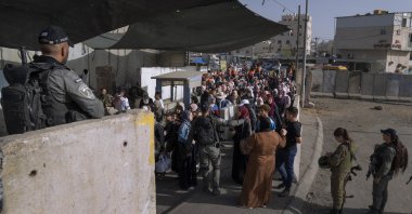 Palestinian women wait to cross the Qalandia checkpoint on their way to pray at the Al-Aqsa Mosque in Jerusalem on the fourth Friday of the Islamic holy month of Ramadan between the West Bank city of Ramallah and Jerusalem, April 29, 2022. (AP Photo)