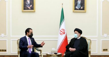 A handout picture provided by the Iranian presidency on April 27, 2022 shows President Ebrahim Raisi (R) meeting with Iraqi Speaker of the Parliament Mohammed al-Halbusi (L) in Tehran, on April 18, 2022. (Photo by HO / Iranian Presidency / AFP)