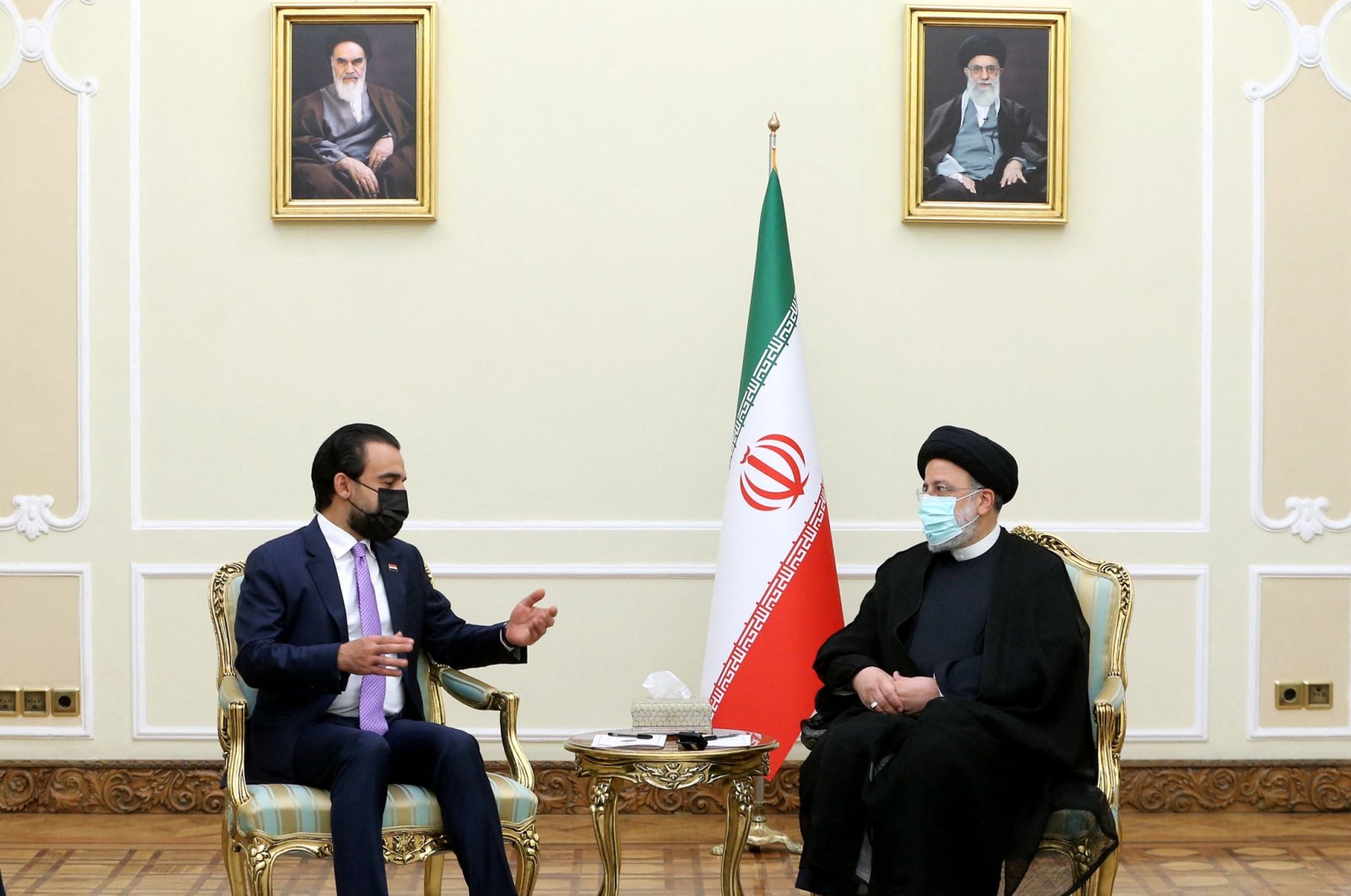 A handout picture provided by the Iranian presidency on April 27, 2022 shows President Ebrahim Raisi (R) meeting with Iraqi Speaker of the Parliament Mohammed al-Halbusi (L) in Tehran, on April 18, 2022. (Photo by HO / Iranian Presidency / AFP)