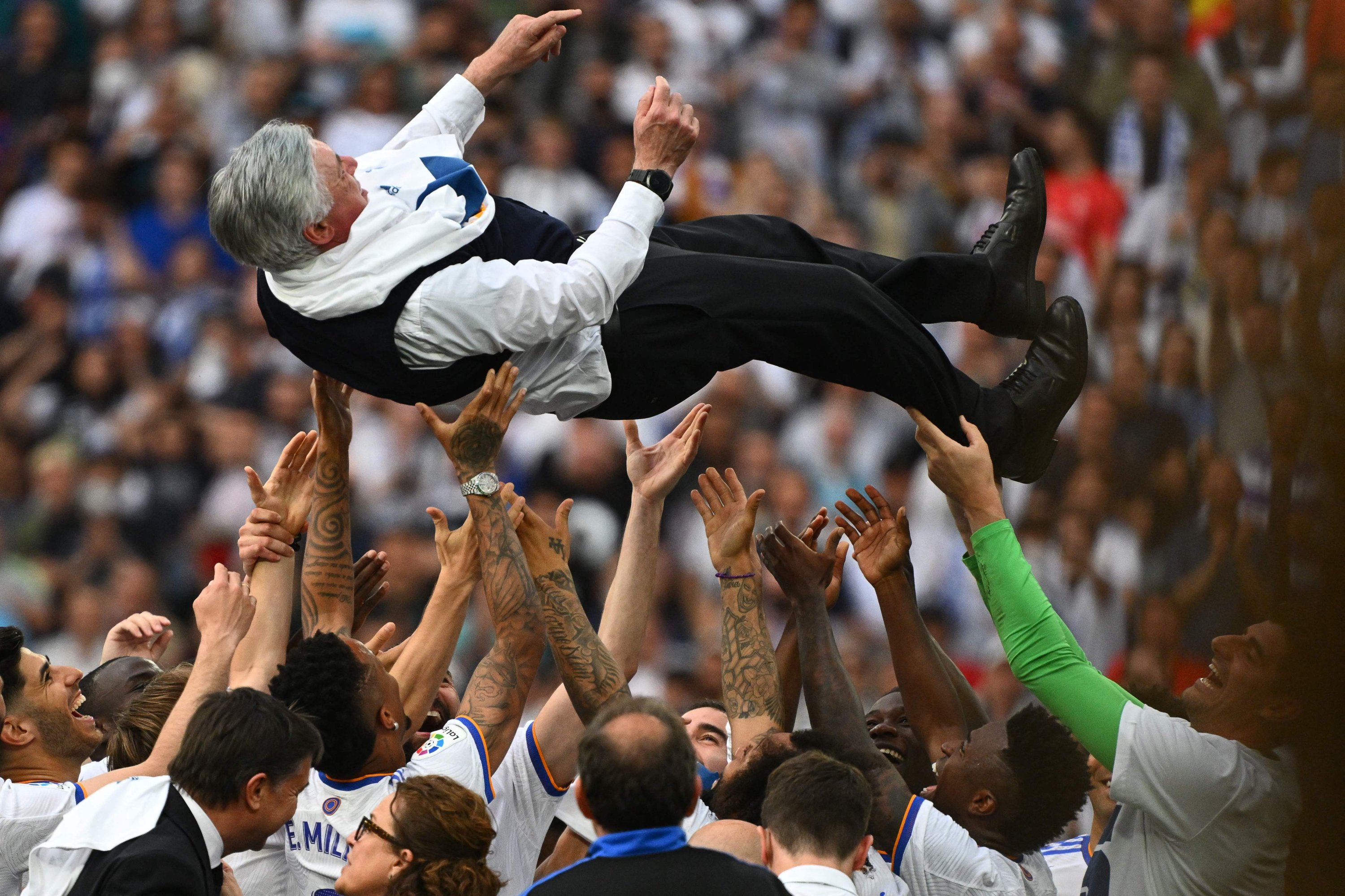 Los jugadores del Real Madrid lanzan al aire al entrenador Carlo Ancelotti después de que se consagró campeón de España, Madrid, 30 de abril de 2022. (Foto AFP)