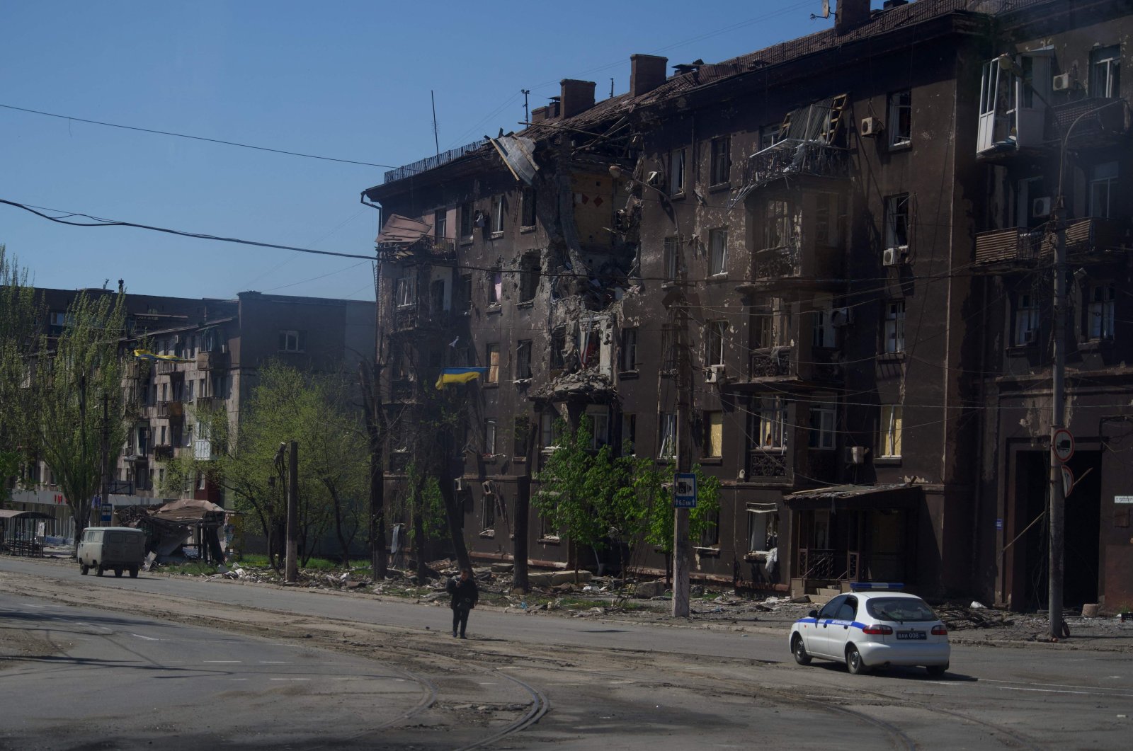 A person walks along a street past a charred residential building amid the ongoing Russian military action in the city of Mariupol, Ukraine, April 29, 2022. (AFP Photo)