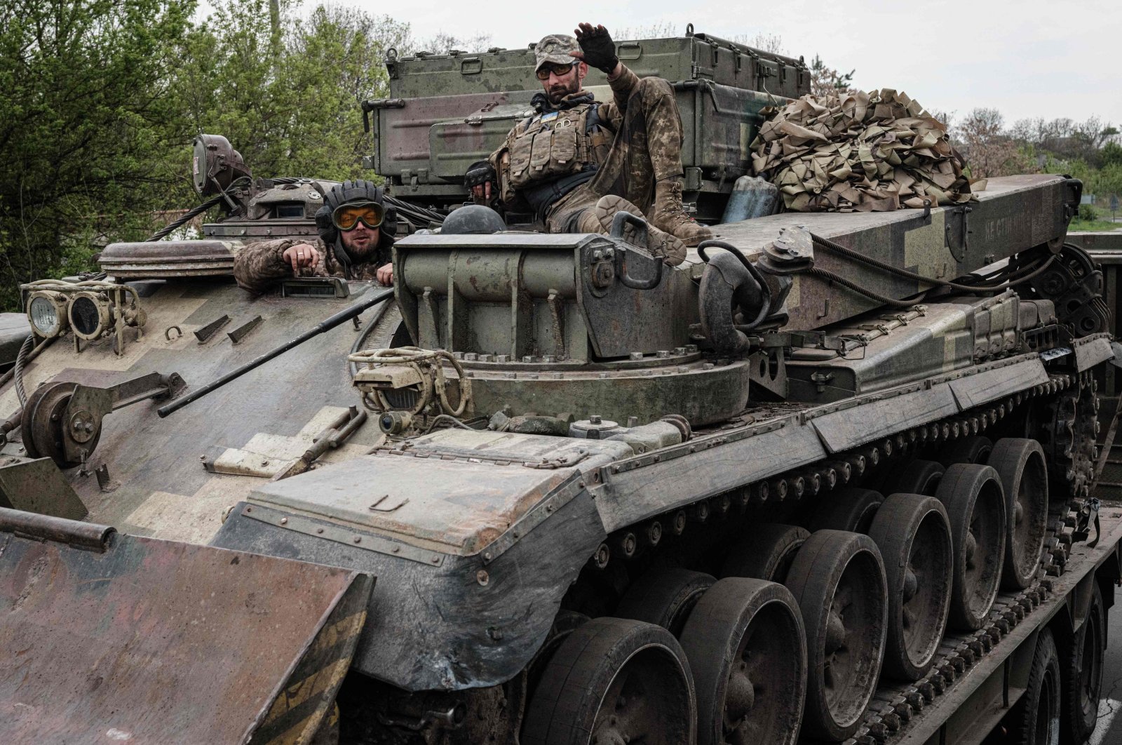 Ukrainian soldiers gesture on an armored engineering vehicle carried on a tank transporter near Kramatorsk, eastern Ukraine, on April 30, 2022, amid the Russian invasion of Ukraine. (Photo by Yasuyoshi CHIBA / AFP)