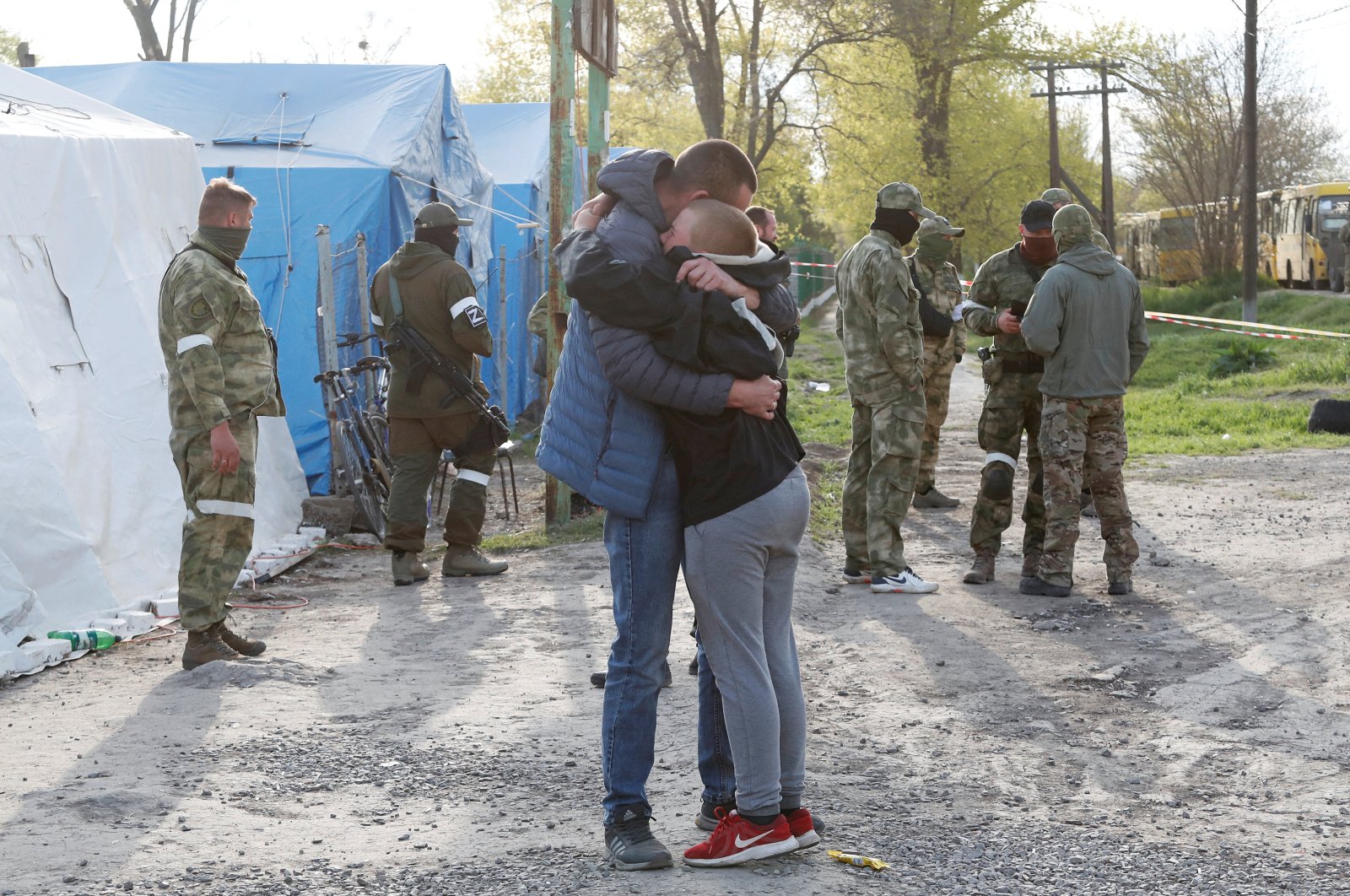 Azovstal steel plant employee Maxim, last name withheld, evacuated from Mariupol, hugs his son Matvey, who had earlier left the city with his relatives, as they meet at a temporary accommodation center during the Ukraine-Russia conflict in the village of Bezimenne in the Donetsk region, Ukraine May 1, 2022. (Reuters Photo)