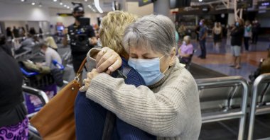Families embrace after a flight from Los Angeles arrived at Auckland International Airport as New Zealand's border opened, May 2, 2022. (AP Photo)