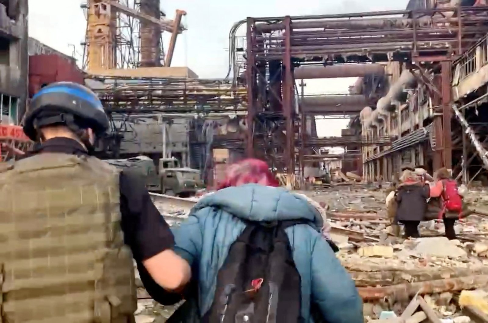 Azov regiment members walk with civilians during U.N.-led evacuations from the sprawling Azovstal steel plant, after nearly two months of siege warfare on the city by Russia during its invasion, in Mariupol, Ukraine in this still image from handout video released May 1, 2022. David Arakhamia/Azov Regiment/Handout via REUTERS THIS IMAGE WAS PROVIDED BY A THIRD PARTY. MANDATORY CREDIT. NO RESALES. NO ARCHIVES.