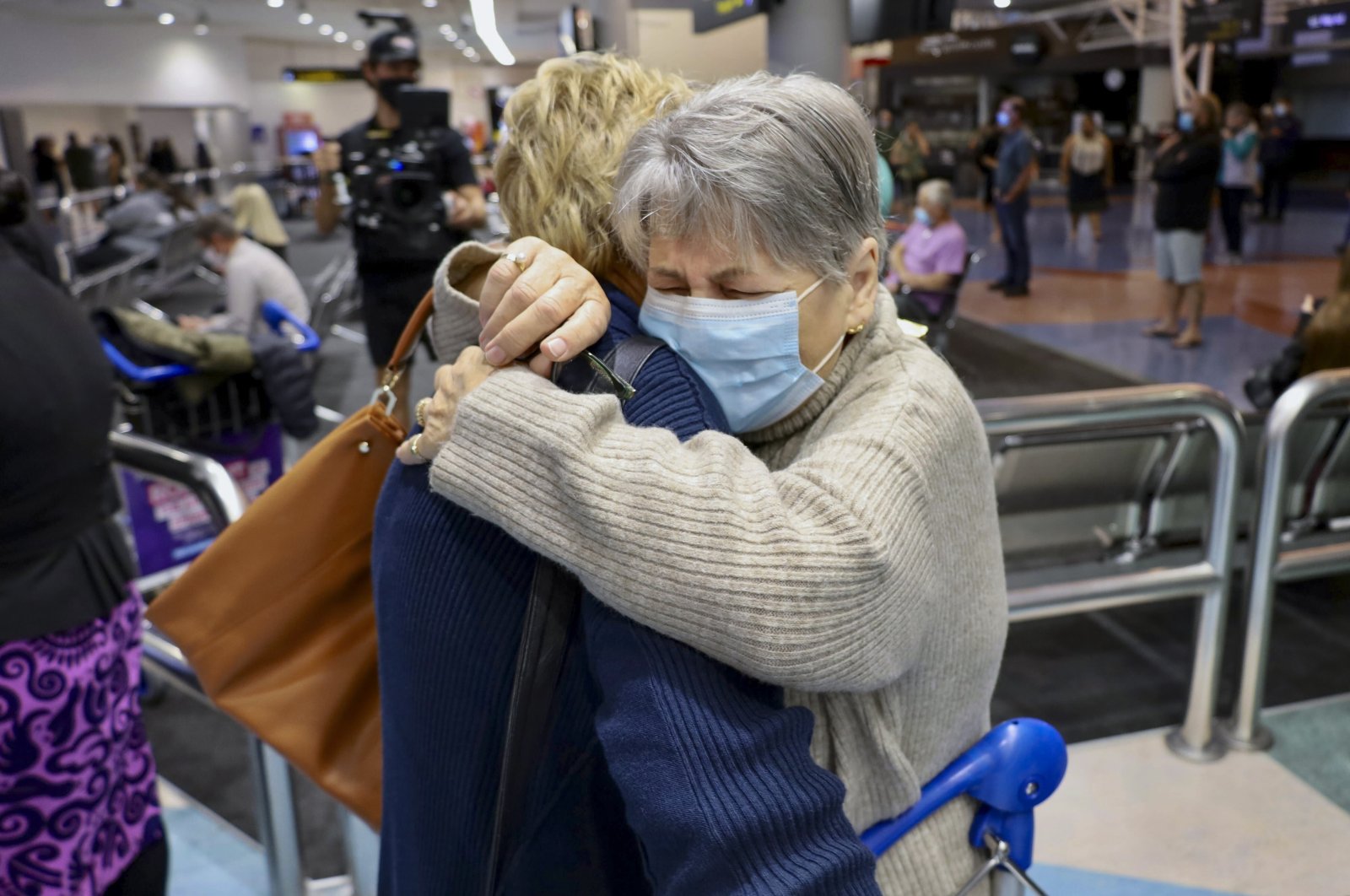 Families embrace after a flight from Los Angeles arrived at Auckland International Airport as New Zealand&#039;s border opened, May 2, 2022. (AP Photo)