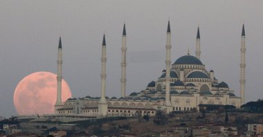 The full moon rises Sunday, March 28, 2021 over the sky in Istanbul, with the Çamlıca Grand Mosque, the largest mosque in Asia Minor. The March full moon is called the "Worm Moon". (AP File Photo)