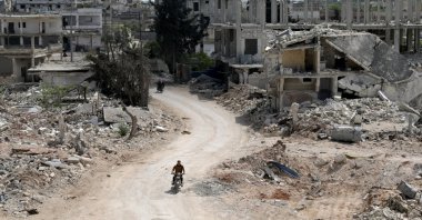 A man rides a motorbike past damaged buildings in the opposition-held town of Nairab, Idlib region, Syria, April 17, 2020. (Reuters File Photo)