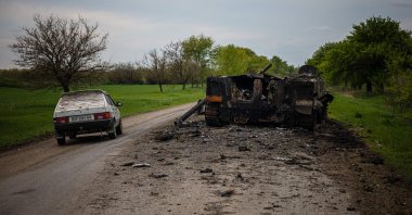 A car passes by a destroyed Russian BMP-3 infantry fighting vehicle on a road near Pokrovske amid the Russian invasion, eastern Ukraine, May 4, 2022. (AFP Photo)