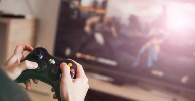 A gamer plays a video game on a gaming console. (Shutterstock Photo)