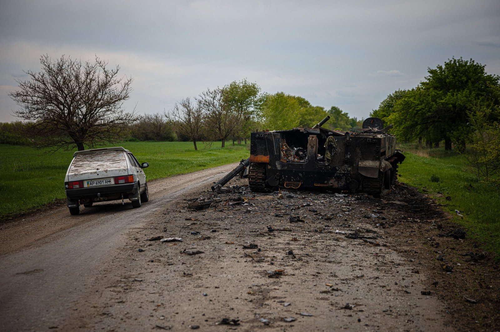 A car passes by a destroyed Russian BMP-3 infantry fighting vehicle on a road near Pokrovske amid the Russian invasion, eastern Ukraine, May 4, 2022. (AFP Photo)