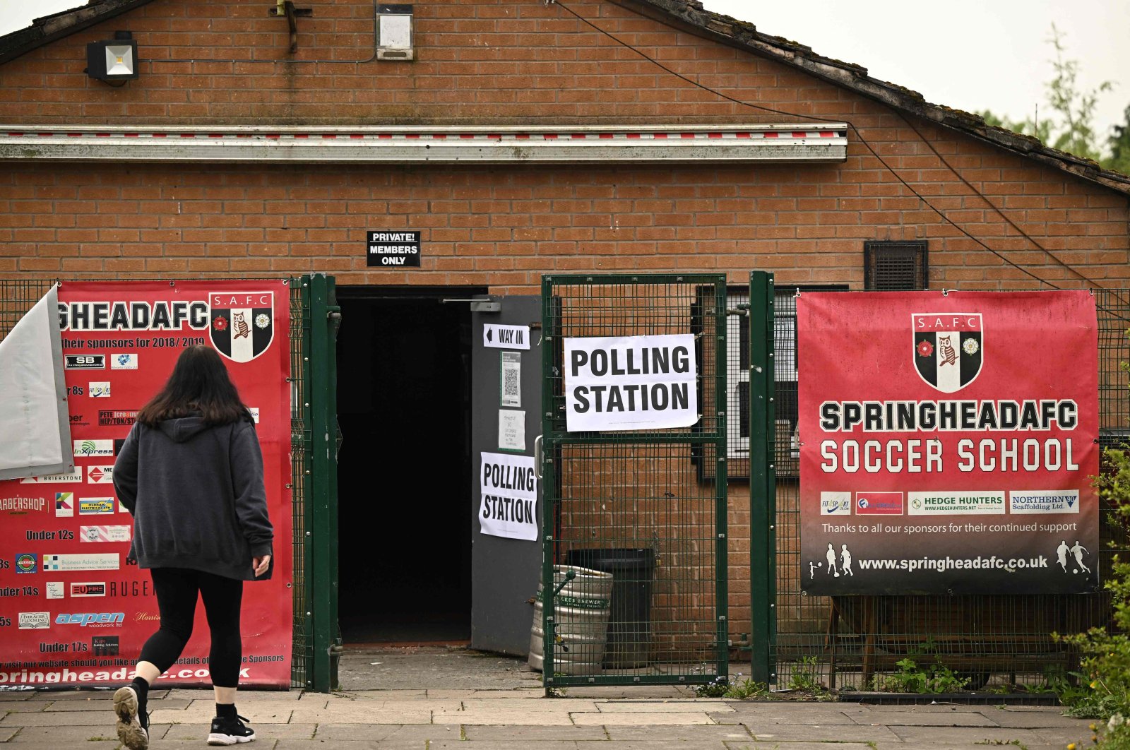 A voter walks into Springhead FC School, being used as a polling station in Lees near Oldham in northern England during local elections, May 5, 2022. (AFP Photo)