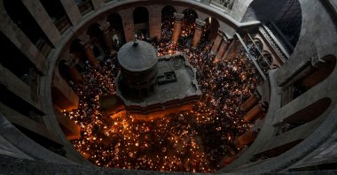 Christian pilgrims hold candles as they gather during the ceremony of the Holy Fire at Church of the Holy Sepulchre in the Old City, East Jerusalem, occupied Palestine, April 23, 2022. (AP Photo)