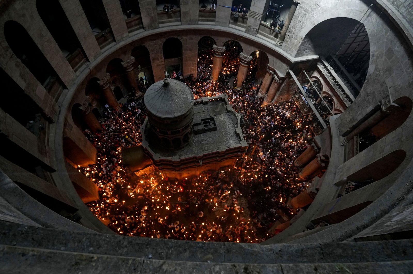 Christian pilgrims hold candles as they gather during the ceremony of the Holy Fire at Church of the Holy Sepulchre in the Old City, East Jerusalem, occupied Palestine, April 23, 2022. (AP Photo)