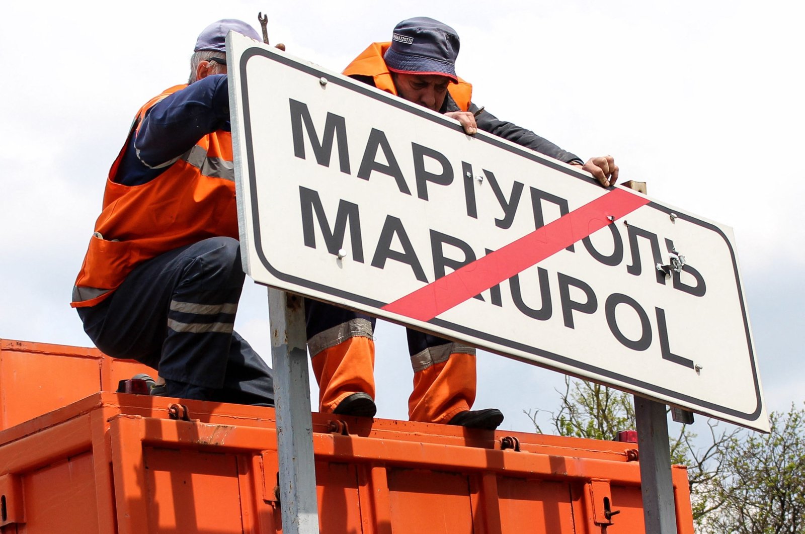 Municipal workers change Ukrainian road signs to Russian outside the city of Mariupol, Ukraine, May 5, 2022. (AFP Photo)