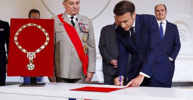 France's Military Chief of Staff to the presidency Benoit Puga (C-L), stands next to French President Emmanuel Macron signing a document during the ceremony of his inauguration for a second term at the Elysee palace, Paris, France, May 7, 2022. (AP Photo)