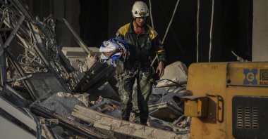 A member of a rescue team recovers a Cuban national flag at the site of a deadly explosion that destroyed the five-star Hotel Saratoga, in Havana, Cuba, May 6, 2022. (AP Photo)
