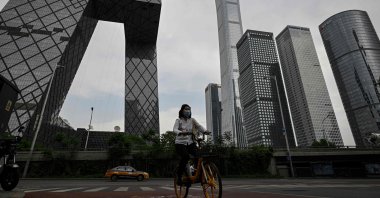 A woman rides a bike in the central business district in Beijing, China, May 5, 2022. (AFP Photo)
