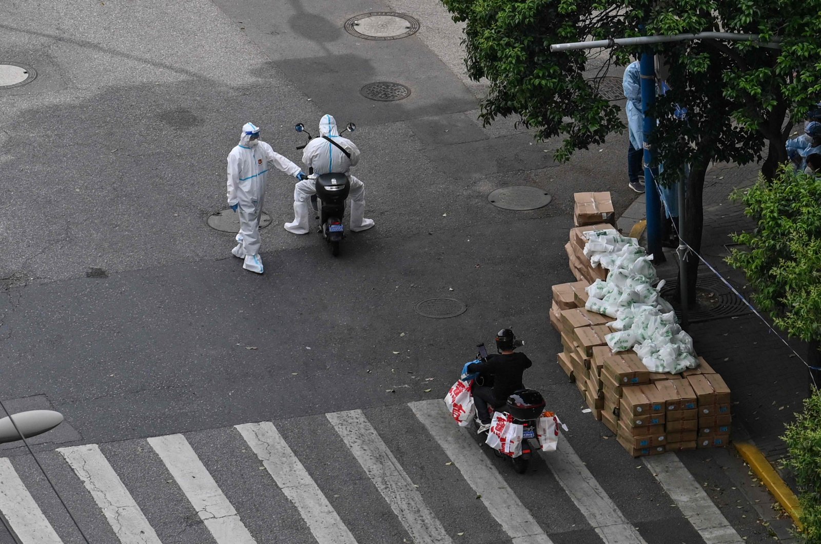 A policeman checks a delivery worker on scooter on the street during a Covid-19 coronavirus lockdown in the Jing&#039;an district in Shanghai, China, May 7, 2022. (AFP Photo)