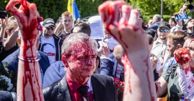 Russian Ambassador to Poland, Ambassador Sergey Andreev reacts after being covered with red paint during a rally for peace in Ukraine in Warsaw, Poland, May 9, 2022. (AFP Photo)