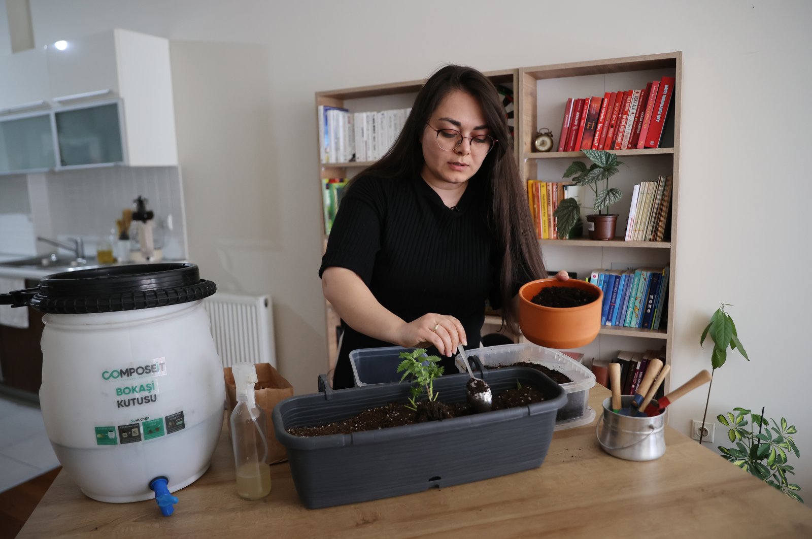 Hiba Sinem Demirkan shows the compost mechanism and the compost she extracted at her home, in Istanbul, Turkey, May 9, 2022. (AA Photo)