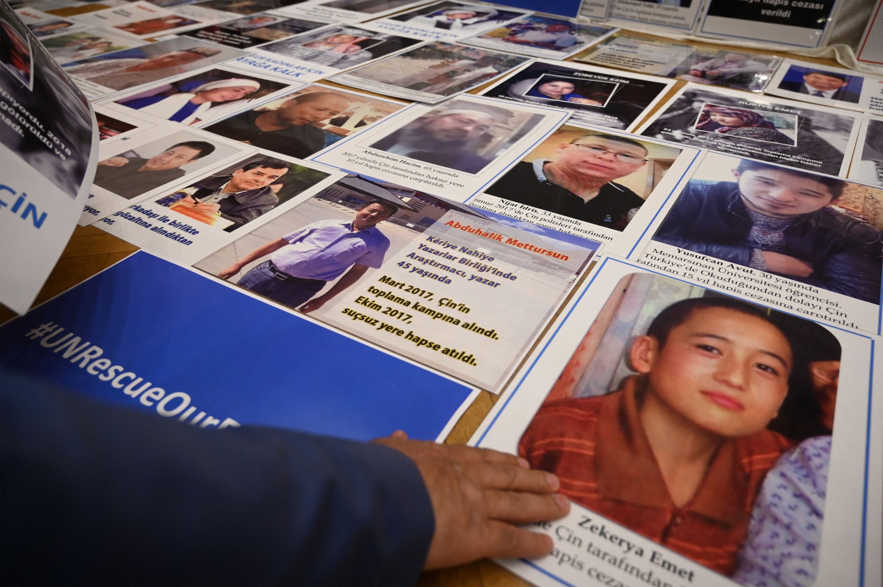 Anggota minoritas Muslim Uyghur menunjukkan foto kerabat mereka yang ditahan di China selama konferensi pers di Istanbul, Turki, 10 Mei 2022. (AFP Photo)