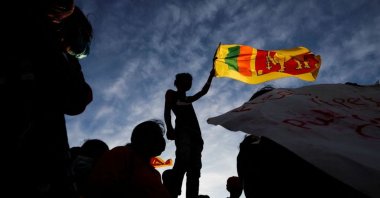 A demonstrator holding the Sri Lankan national flag is silhouetted during the protest against Sri Lankan President Gotabaya Rajapaksa, near the Presidential Secretariat, amid the country's economic crisis, Colombo, Sri Lanka, April 15, 2022. (Reuters Photo)