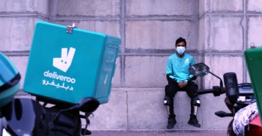 A food-delivery worker for Deliveroo takes a moment as he returns to work in Dubai, United Arab Emirates, May 2, 2022.  (AP Photo)