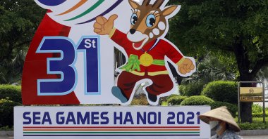 A woman rides bicycle past a banner advertising the 31st Southeast Asian Games, Hanoi, Vietnam, April 25, 2022. (EPA Photo)
