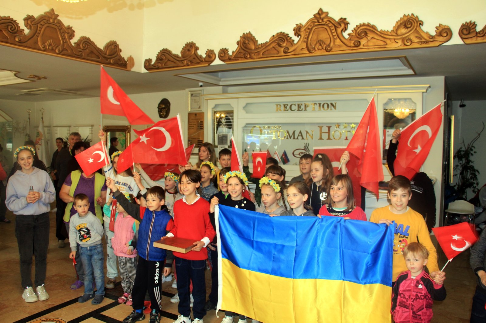 Ukrainian children accommodated at a hotel by the government hold a Ukrainian flag and wave Turkish flags, in Sakarya, northwestern Turkey, May 3, 2022. (İHA PHOTO)
