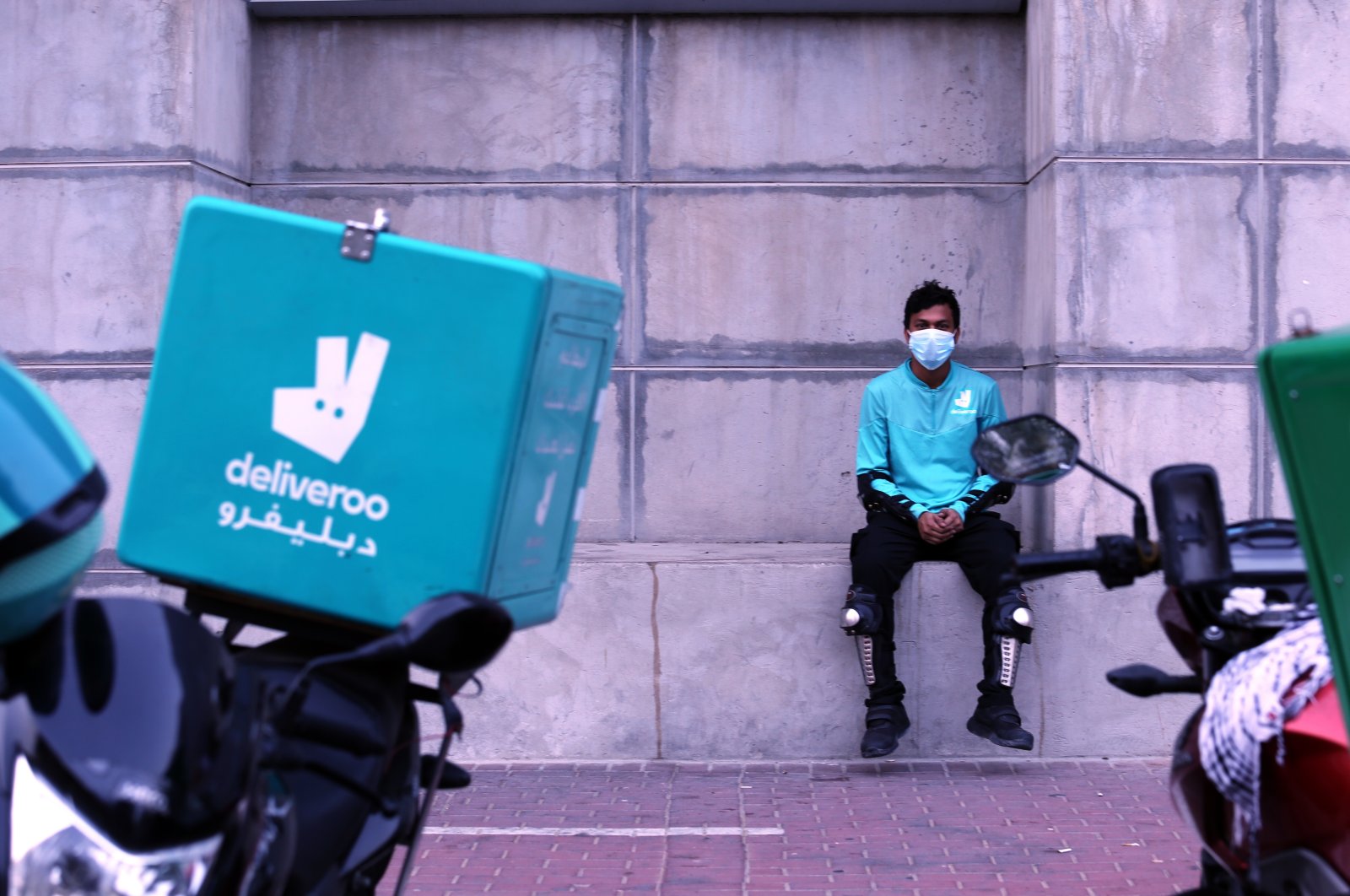 A food-delivery worker for Deliveroo takes a moment as he returns to work in Dubai, United Arab Emirates, May 2, 2022.  (AP Photo)