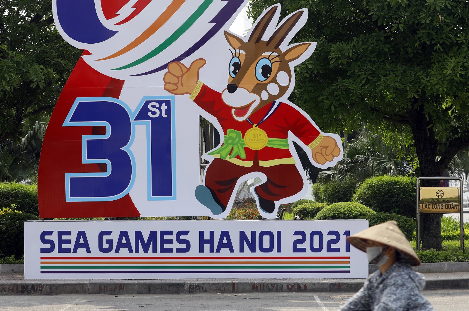 A woman rides bicycle past a banner advertising the 31st Southeast Asian Games, Hanoi, Vietnam, April 25, 2022. (EPA Photo)