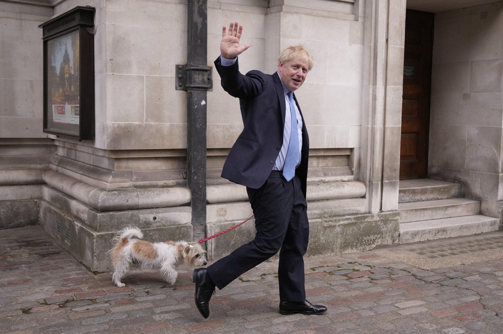 Britain&#039;s Prime Minister Boris Johnson waves at the media as he leaves with his dog Dilyn after voting at a polling station in London, for local council elections, London, Britain, May 5, 2022. (AP Photo)