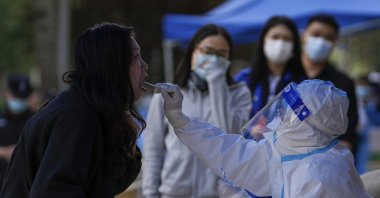 Residents get a throat swab for COVID-19 testing in the Chaoyang district, Beijing, China, May 11, 2022. (AP Photo)