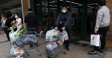 A customer pushes a cart carrying bags of goods as he leaves a supermarket in Beijing, China, April 25, 2022. (Reuters Photo)