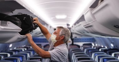 A passenger wears personal protective equipment on a Delta Airlines flight after landing in Minneapolis, United States of America, May 28, 2020. (AP File Photo)