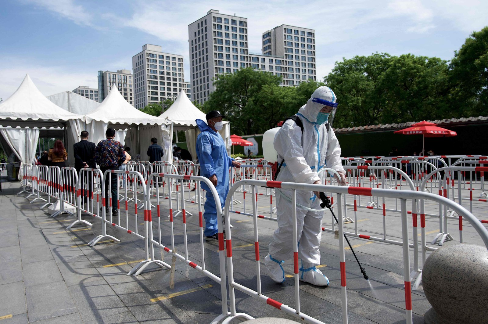 A worker disinfects the queue area of a swab test collection site for COVID-19 in Beijing, China, May 11, 2022. (AFP Photo)
