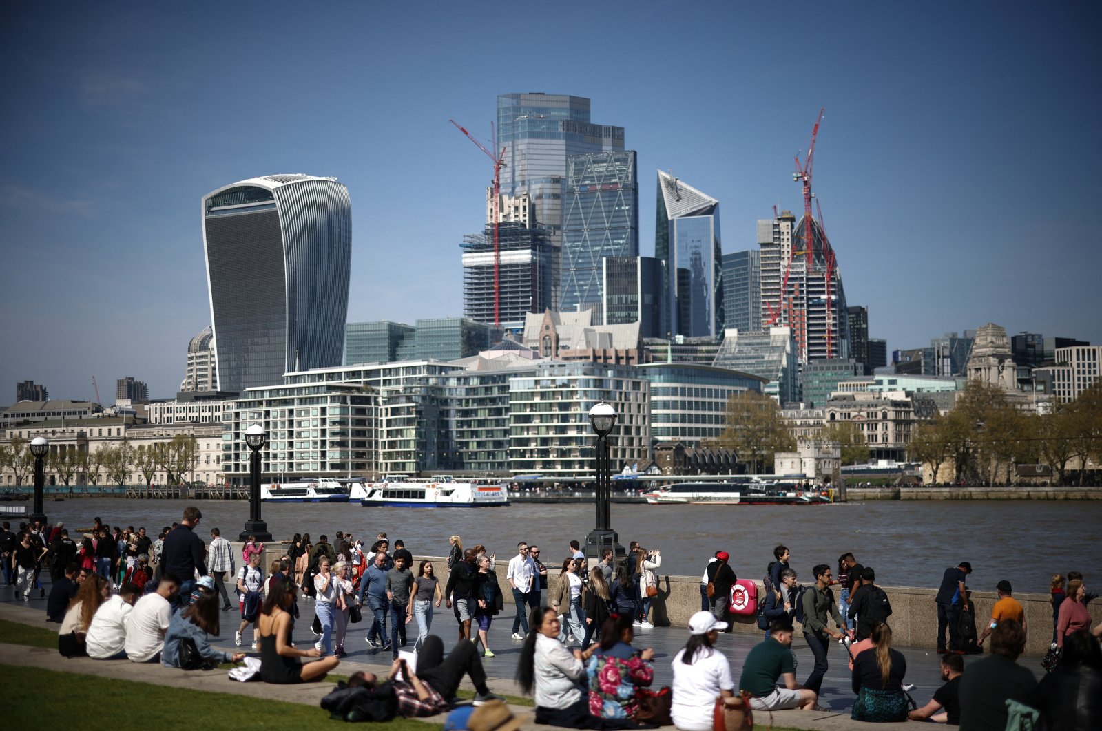People walk along the River Thames during sunny weather in central London, Britain, April 16, 2022. (Reuters Photo)