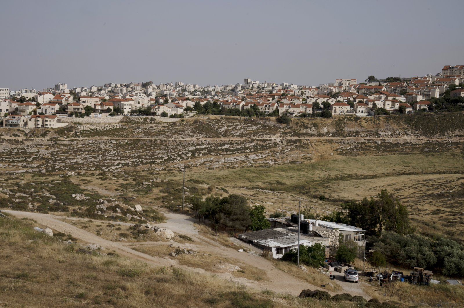 A Palestinian home sits in a valley, located next to the Israeli settlement of Pisgat Ze&#039;ev, East Jerusalem, occupied Palestine, May 12, 2022. (AP Photo)
