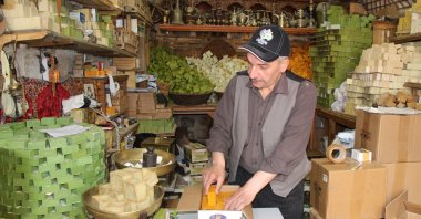 Mehmet Dede poses with soaps in his shop, in Mardin, southeastern Turkey, May 13, 2022. (IHA PHOTO)