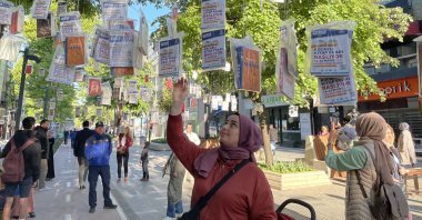 People pick books hanging from trees, in Kocaeli, northwestern Turkey, May 13, 2022. (AA PHOTO)